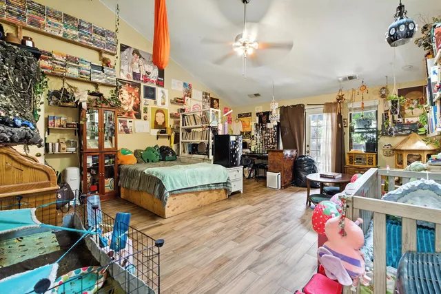 a view of a patio with table and chairs potted plants and large tree