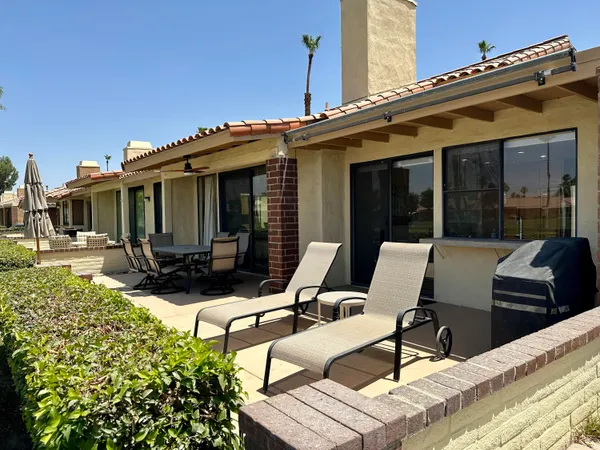 a view of a patio with table and chairs with wooden floor and fence