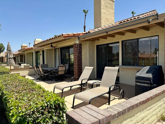 a view of a patio with table and chairs with wooden floor and fence