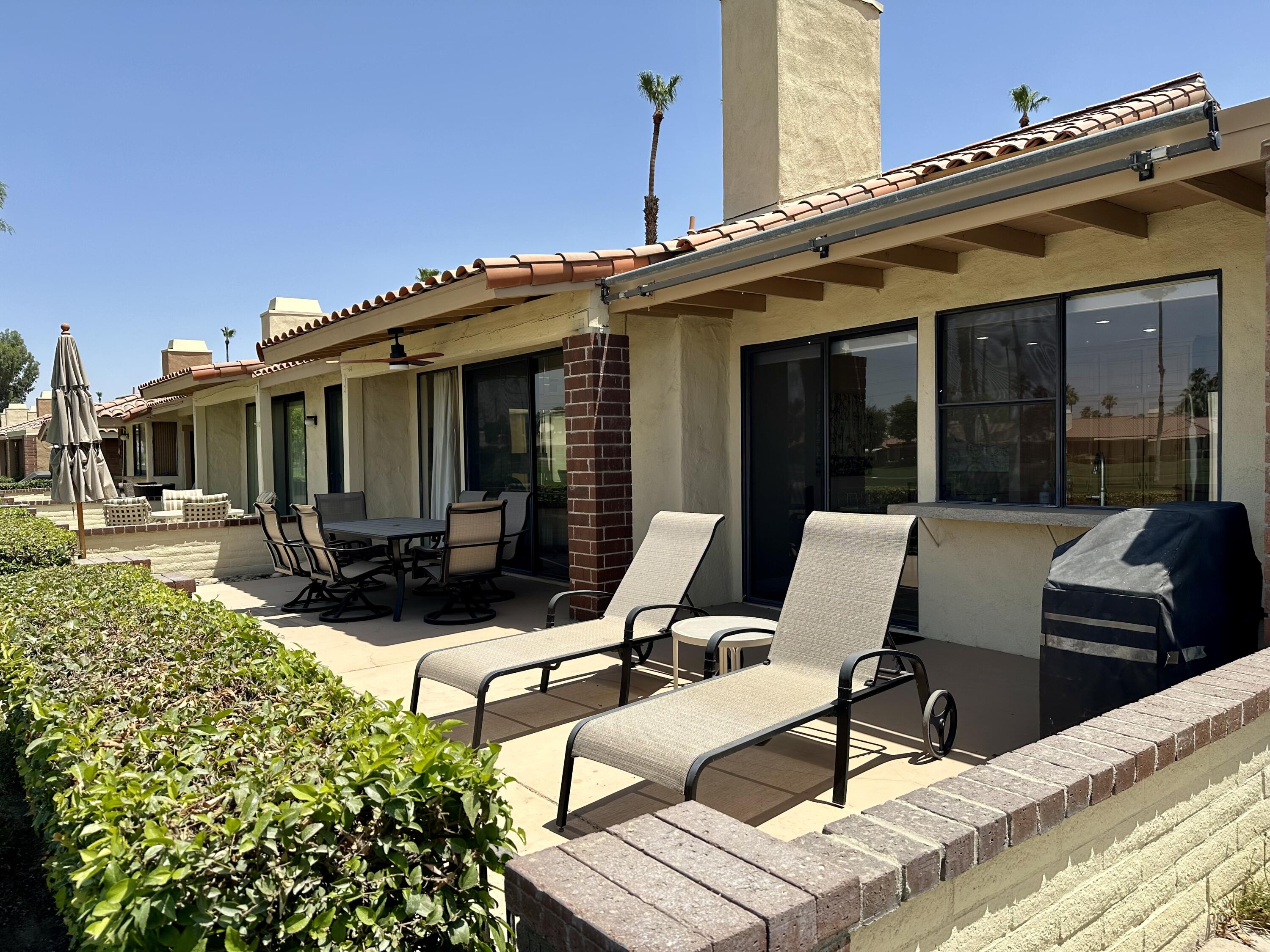 214 La Paz Way Palm Desert, CA 92260 - Photo 3 of 15 a view of a patio with table and chairs with wooden floor and fence