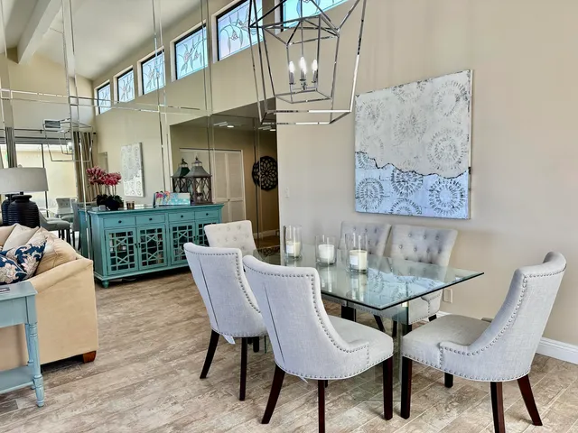 a view of a dining room with furniture a chandelier and wooden floor