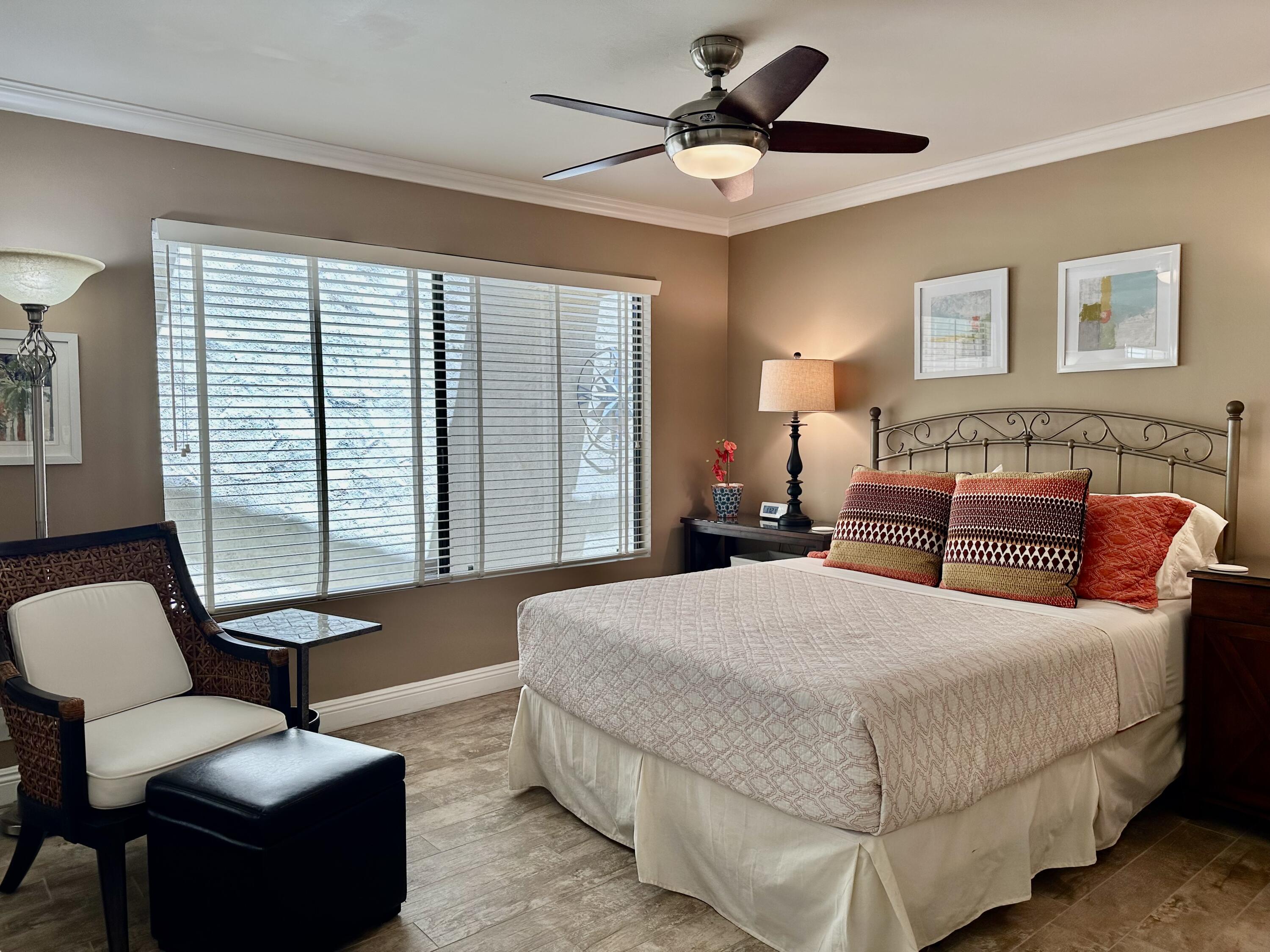 214 La Paz Way Palm Desert, CA 92260 - Photo 10 of 15 a bedroom with bed couch and window