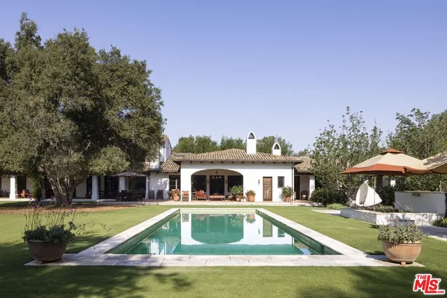 a view of a house with swimming pool and sitting area