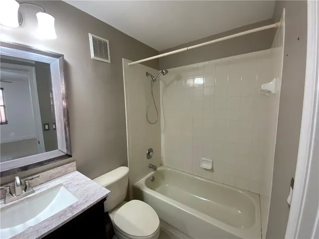 a bathroom with a sink toilet vanity and shower