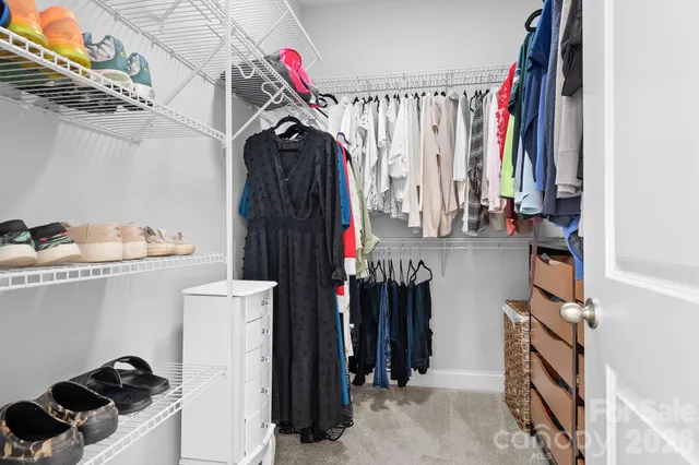 a view of walk in closet with clothes and shoes