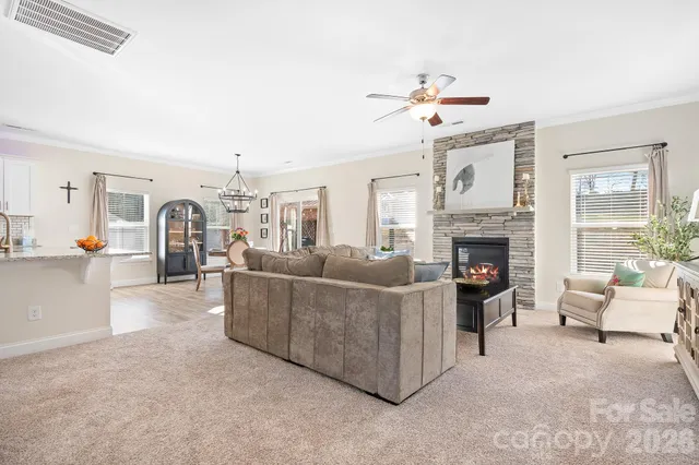 a living room with furniture a fireplace and a chandelier