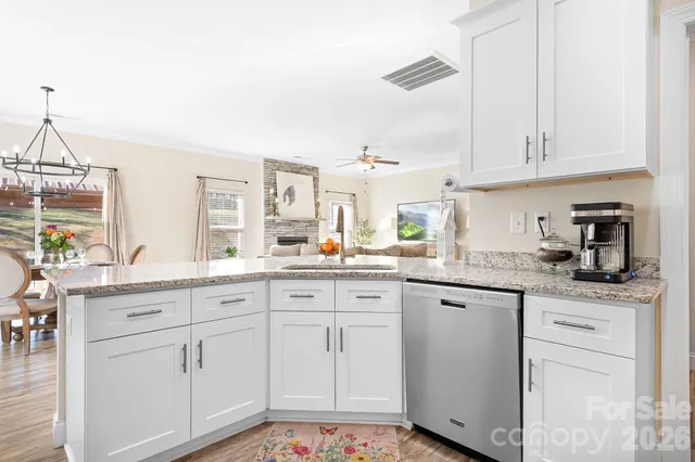 a kitchen with granite countertop white cabinets white appliances and sink