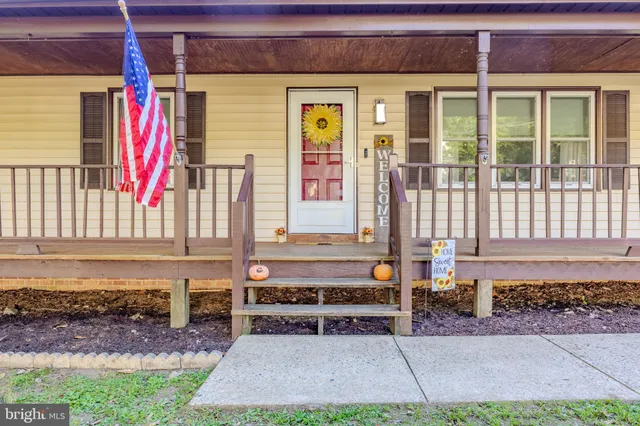 a view of a house with a small yard and wooden floor and fence