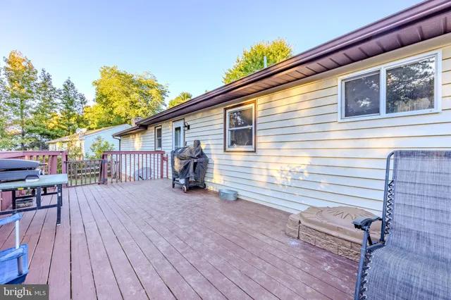 a view of a house with wooden deck and furniture