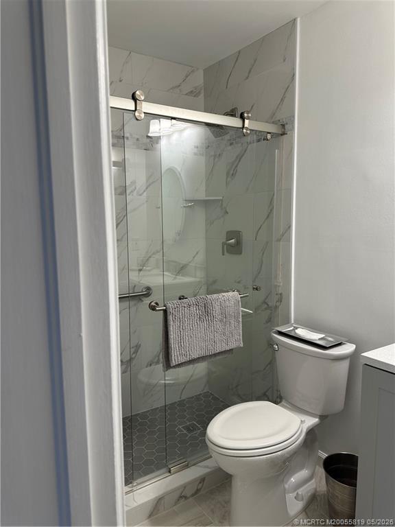 755 Saturn Street, Unit F205 Jupiter, FL 33477 - Photo 11 of 19 a white toilet sitting next to a bathroom sink