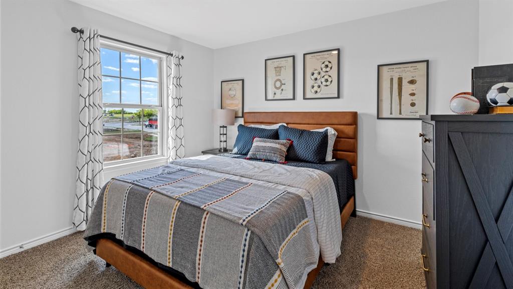 500 Range Road Caddo Mills, TX 75135 - Photo 6 of 35 Carpeted bedroom featuring a large window with white trim, white walls, and a warm-toned headboard