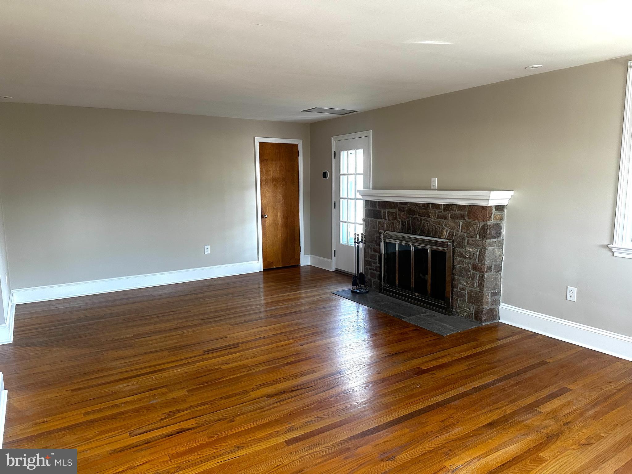 659 North Main Street Doylestown, PA 18901 - Photo 15 of 22 an empty room with wooden floor fireplace and windows