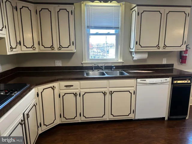 a kitchen with white cabinets a sink and dishwasher