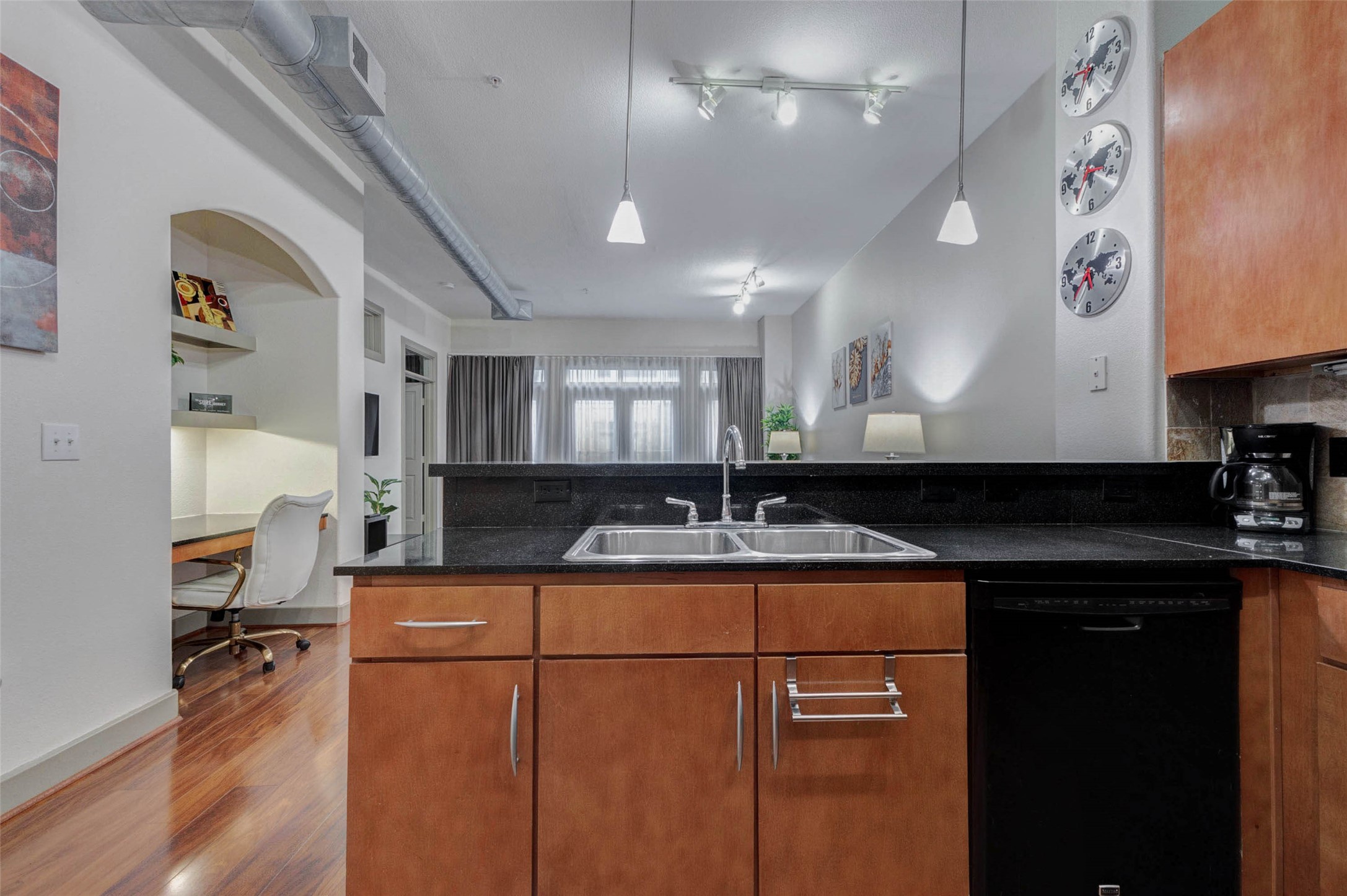 1901 Post Oak Boulevard, Unit 1106 Houston, TX 77056 - Photo 8 of 26 a kitchen with kitchen island granite countertop a sink cabinets and wooden floor
