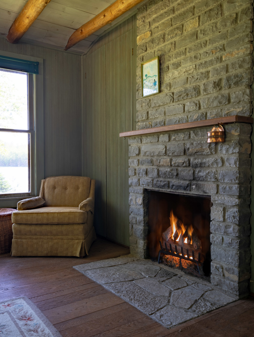 5021 Solomon Road Atlanta, MI 49709 - Photo 26 of 34 a living room with furniture a fireplace and a window
