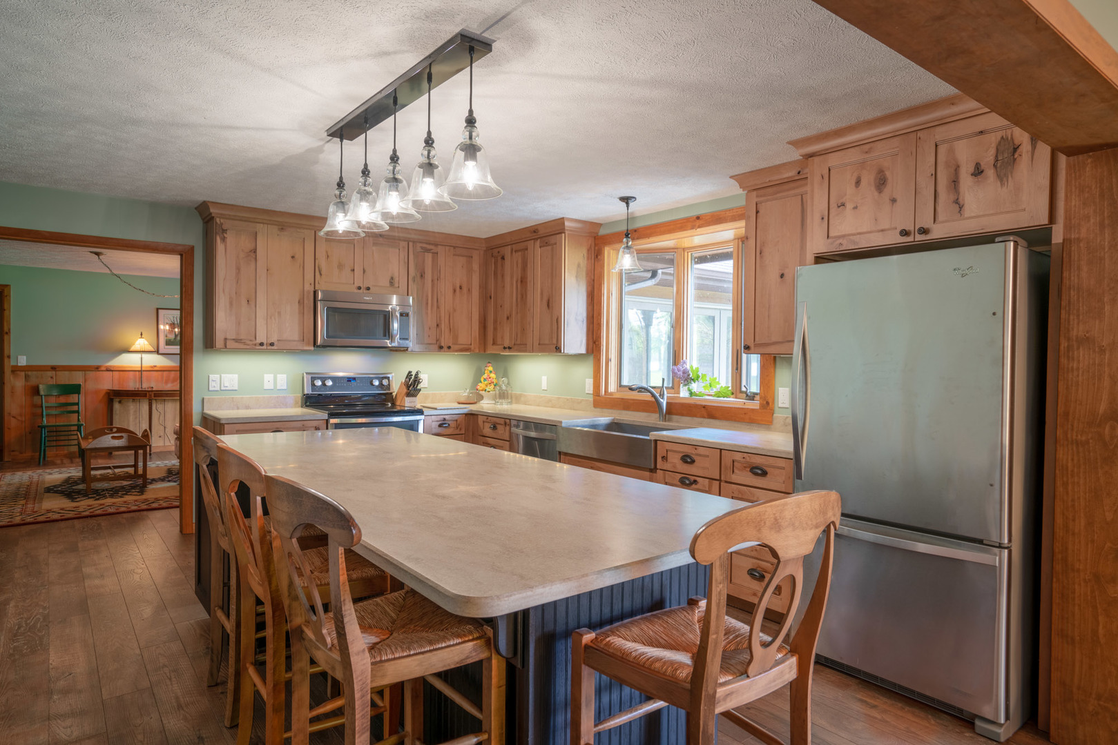 5021 Solomon Road Atlanta, MI 49709 - Photo 8 of 34 a kitchen with stainless steel appliances granite countertop a refrigerator a sink a stove a dining table and chairs
