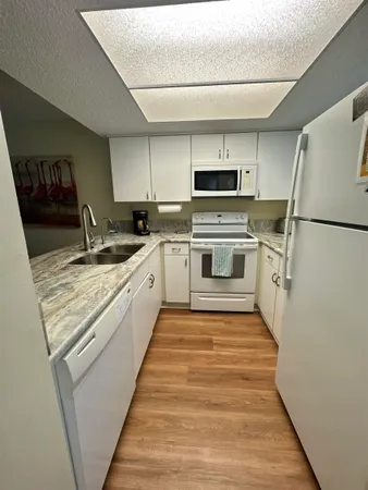 a kitchen with a sink a stove top oven and refrigerator