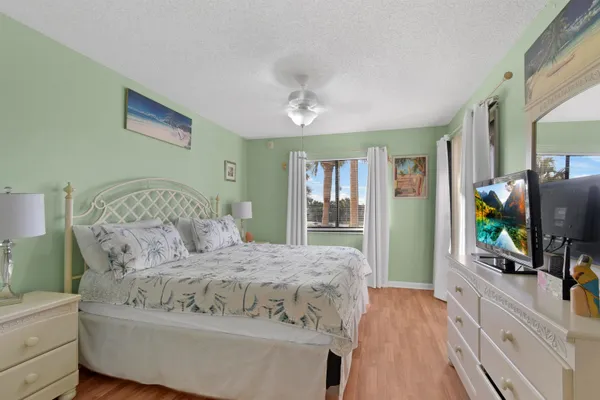 a bedroom with a bed and a flat tv screen on dresser