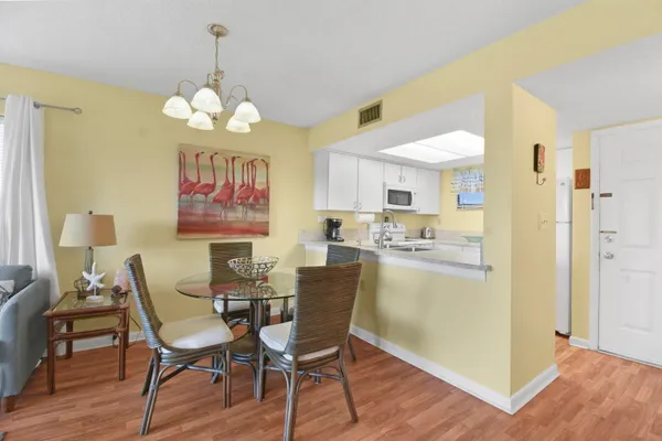 a view of a dining room with furniture a chandelier and wooden floor