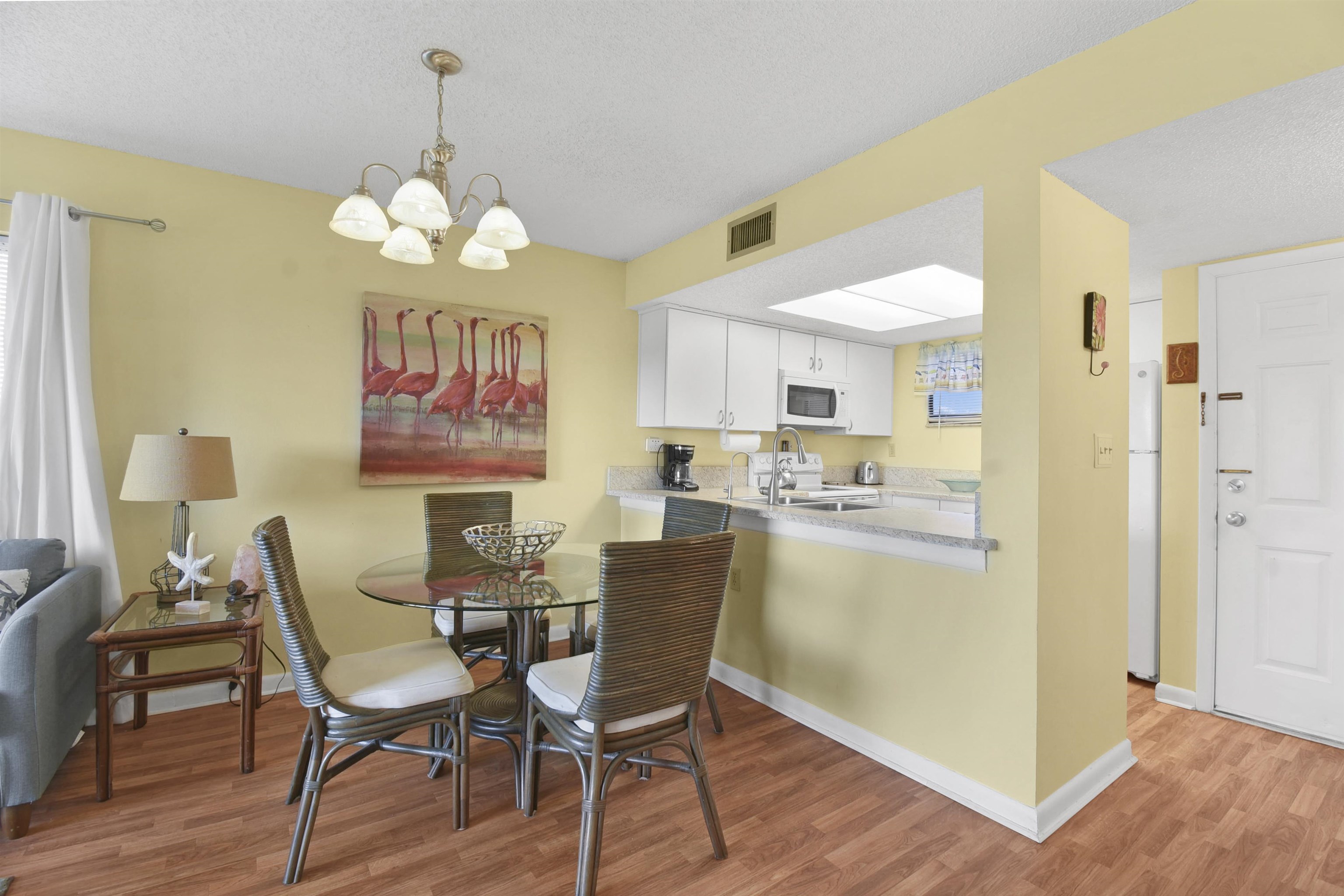 4250 A1A South, Unit C26 St. Augustine, FL 32080 - Photo 20 of 39 a view of a dining room with furniture a chandelier and wooden floor