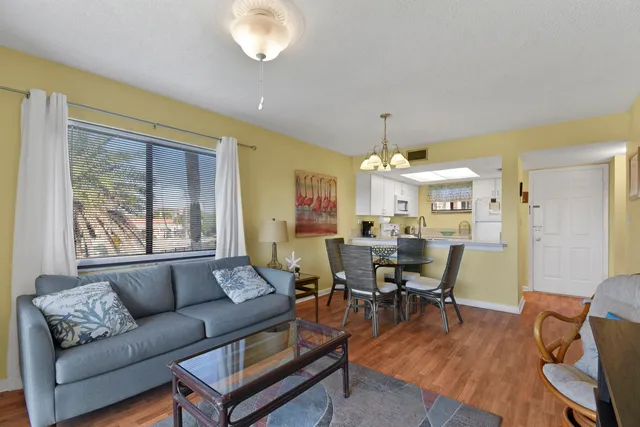 a living room with furniture a chandelier and a dining table