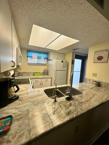 a view of a kitchen with kitchen island a sink and wooden floor