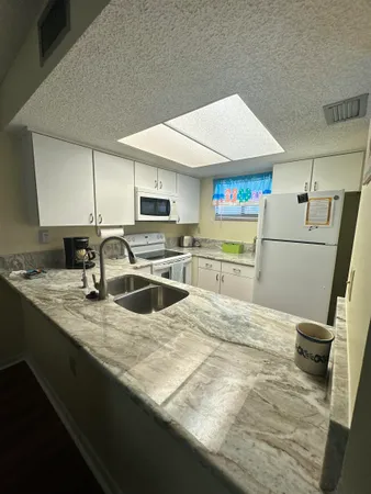 a kitchen with stainless steel appliances granite countertop a sink refrigerator and cabinets