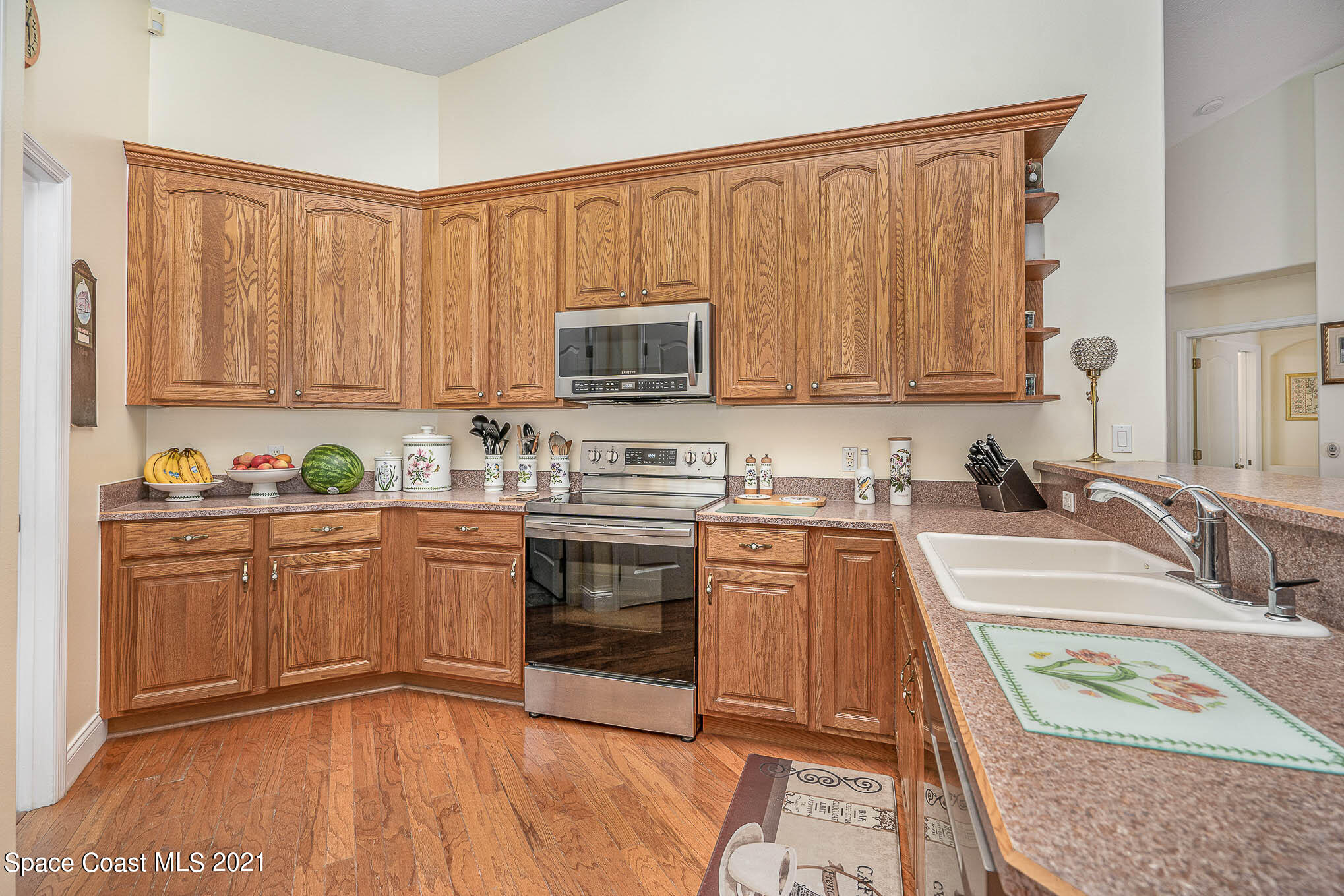 5080 Craig Road Cocoa, FL 32926 - Photo 11 of 41 a kitchen with stainless steel appliances granite countertop a stove a sink dishwasher and a microwave oven with wooden cabinets