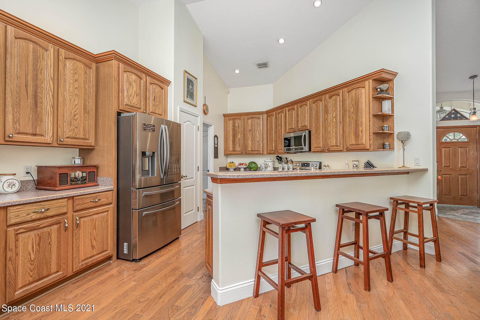 5080 Craig Road Cocoa, FL 32926 - Photo 10 of 41 a kitchen with stainless steel appliances granite countertop a refrigerator a stove a sink a dining table and chairs with wooden floor