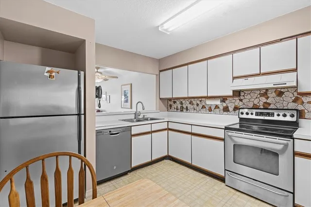 a kitchen with granite countertop white cabinets and white appliances