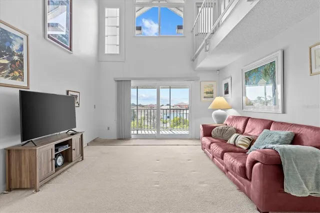 a living room with furniture a flat screen tv and a floor to ceiling window