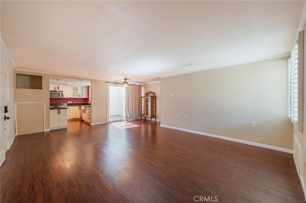 43 Calle Aragon, Unit C Laguna Woods, CA 92637 - Photo 14 of 41 a view of empty room with wooden floor and kitchen