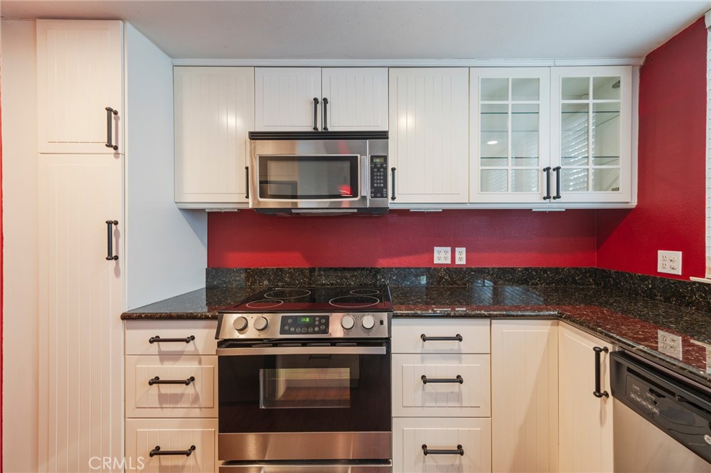 43 Calle Aragon, Unit C Laguna Woods, CA 92637 - Photo 18 of 41 a kitchen with stainless steel appliances granite countertop a stove and a microwave