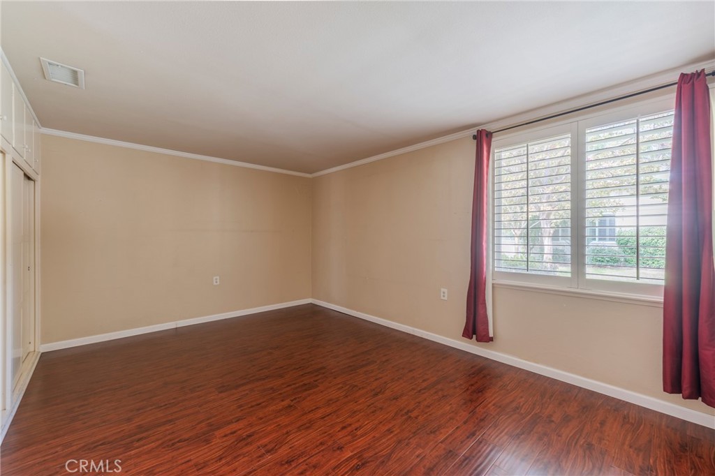 43 Calle Aragon, Unit C Laguna Woods, CA 92637 - Photo 22 of 41 a view of an empty room with wooden floor and a window