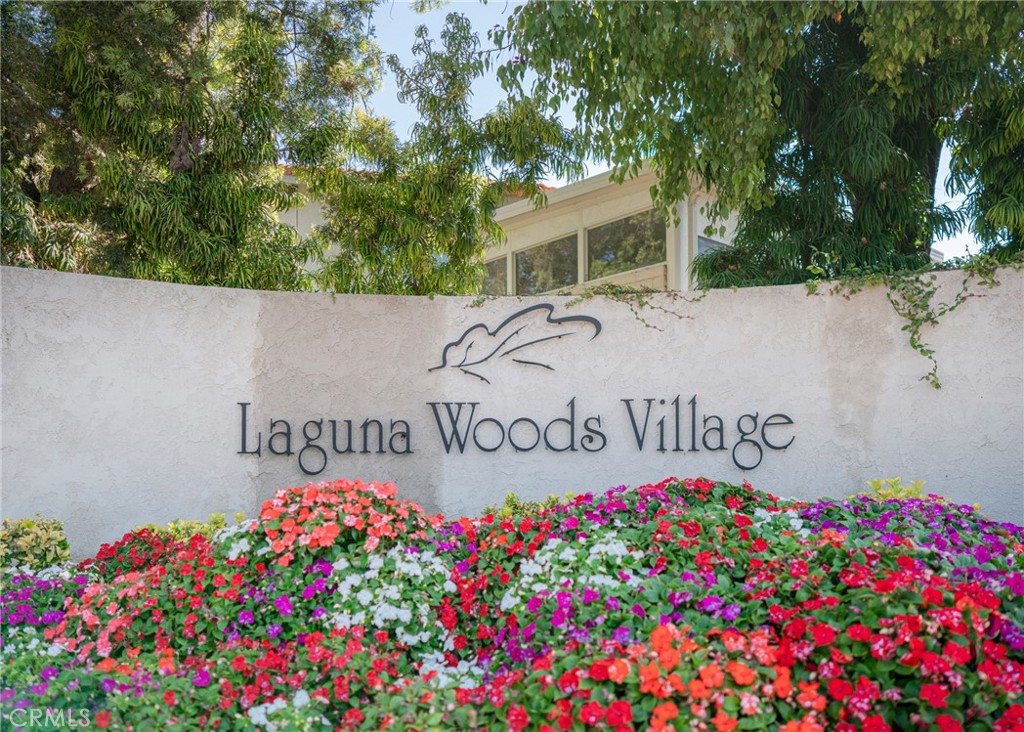 43 Calle Aragon, Unit C Laguna Woods, CA 92637 - Photo 41 of 41 a sign that is in front of flowers