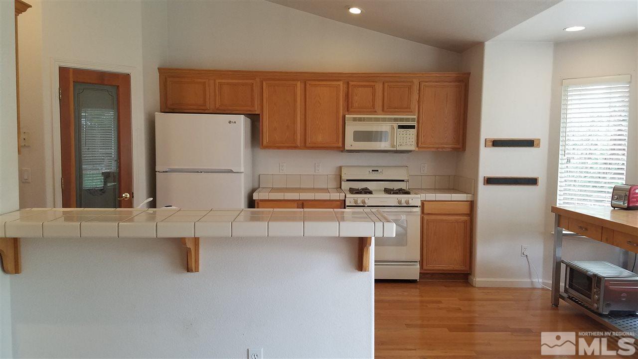 706 Putnam Court Reno, NV 89503 - Photo 7 of 20 a kitchen with a refrigerator and a stove top oven