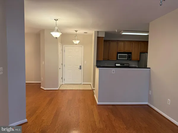 a view of a kitchen with a sink and dishwasher with wooden floor