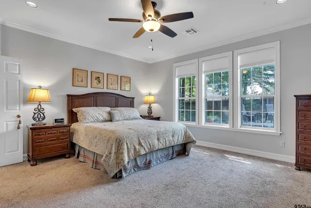 a spacious bedroom with a bed and a chandelier
