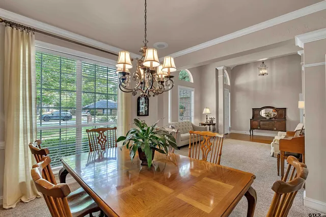 a dining room with furniture a chandelier and wooden floor
