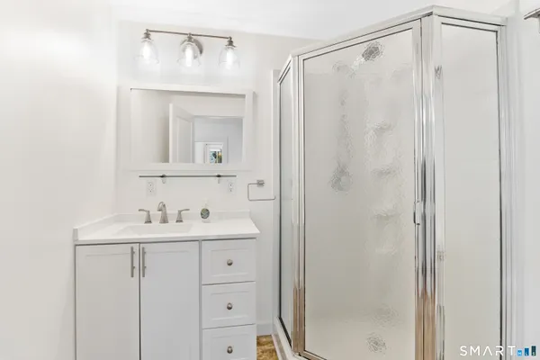 a bathroom with a shower a sink and a mirror