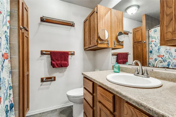 a bathroom with a sink a toilet and a mirror