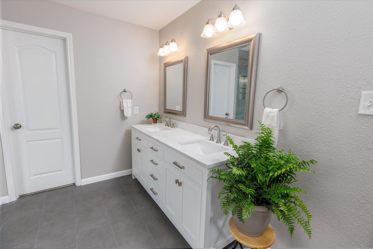 7136 Ridge Oak Road Austin, TX 78749 - Photo 21 of 28 Double vanity with sleek countertops offers ample space in this well-appointed bathroom.