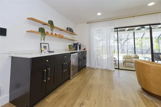 a kitchen with kitchen island a sink wooden floor and glass door