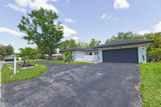 a view of a house with a yard and garage