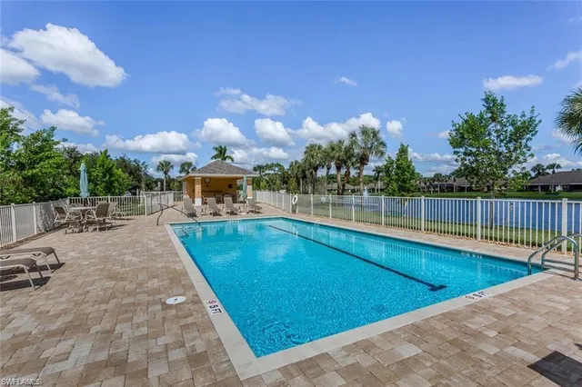 a view of a swimming pool with a patio and a yard