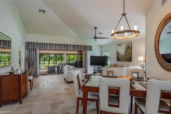 a living room with furniture a flat screen tv and a large window