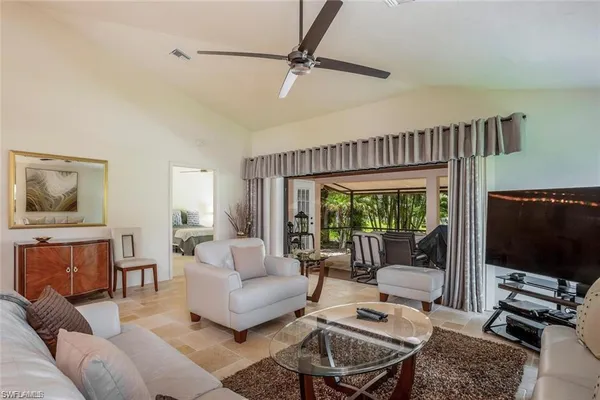 a living room with furniture a flat screen tv and a window