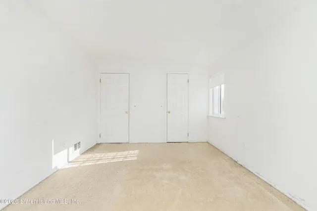 an empty room with a window and a ceiling fan