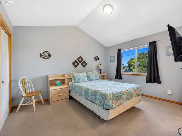 a bedroom with a bed chair and a flat screen tv
