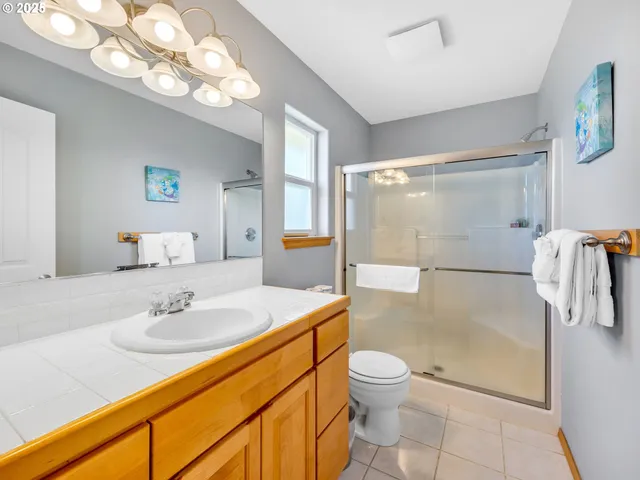 a bathroom with a granite countertop sink a toilet and shower